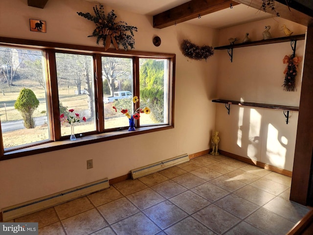 empty room with a baseboard heating unit, beam ceiling, and baseboards