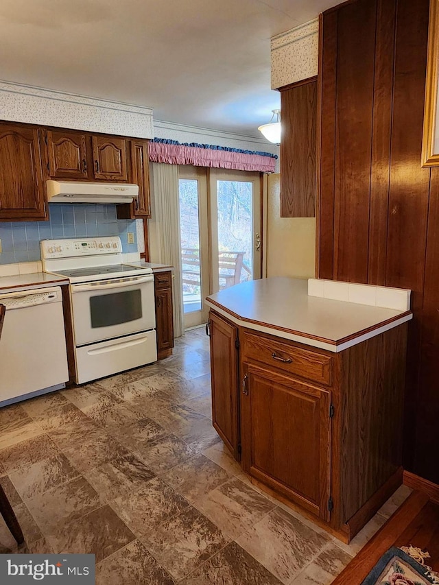 kitchen featuring white appliances, under cabinet range hood, light countertops, and backsplash