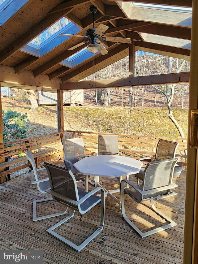 wooden terrace with a ceiling fan and outdoor dining area