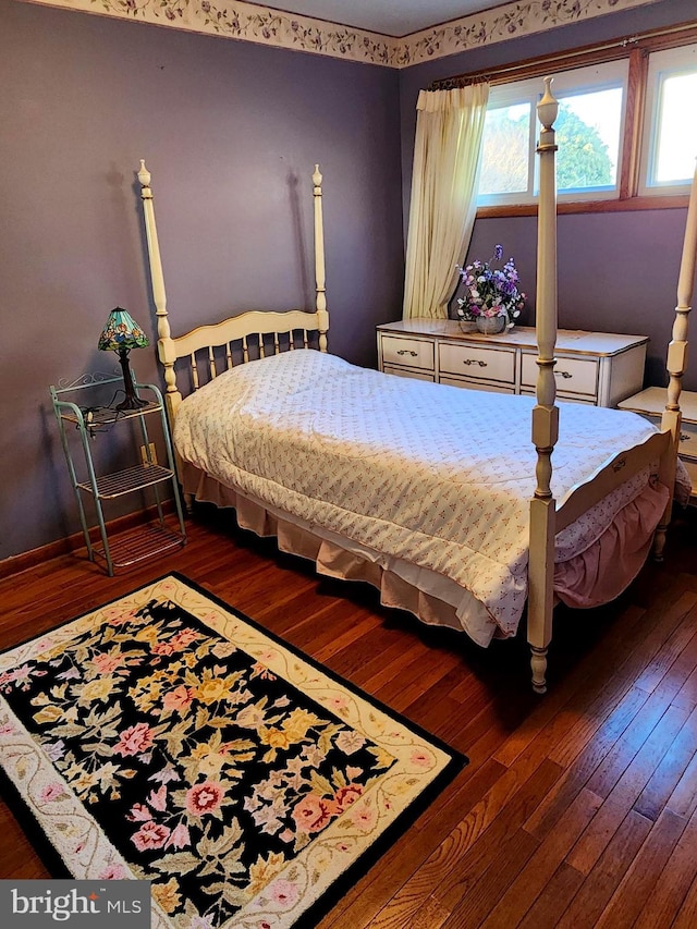 bedroom featuring hardwood / wood-style floors, multiple windows, and baseboards