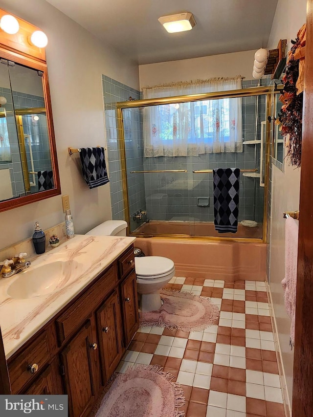 full bathroom with toilet, bath / shower combo with glass door, and vanity