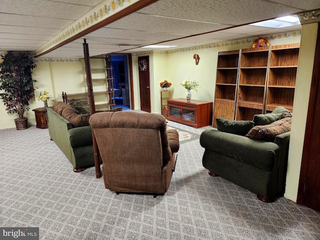 living area with carpet floors and a paneled ceiling