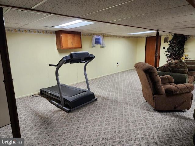 exercise room with a drop ceiling, carpet flooring, and baseboards