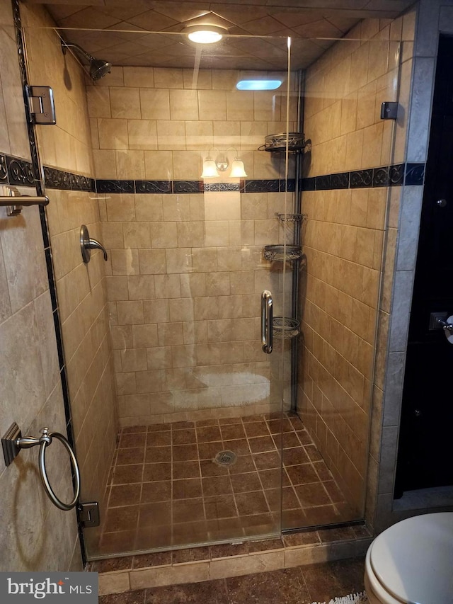 full bath featuring toilet and a shower stall