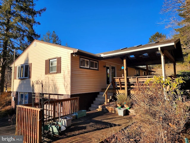 rear view of house with a wooden deck and french doors