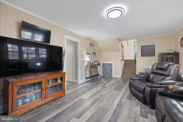 living room featuring lofted ceiling, wood finished floors, crown molding, and stairs