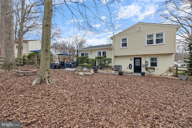 rear view of house with a patio, cooling unit, and fence