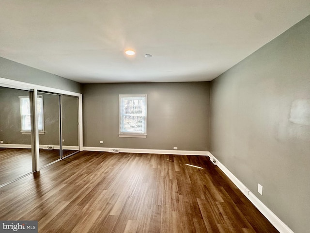 unfurnished bedroom with dark wood-style floors and baseboards