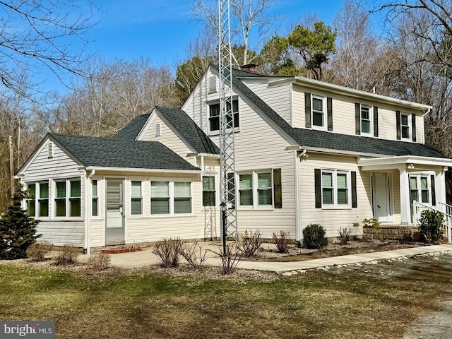 traditional-style house with a chimney and a shingled roof