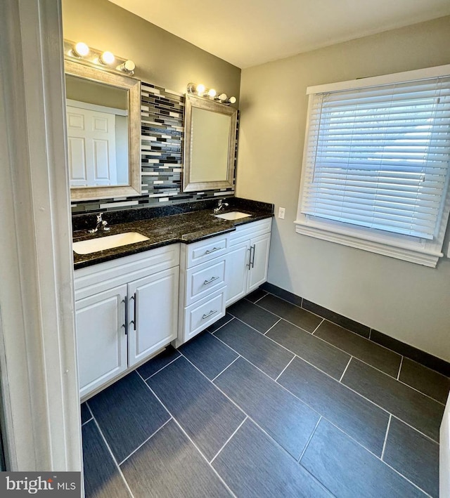 full bathroom featuring a sink, backsplash, and double vanity