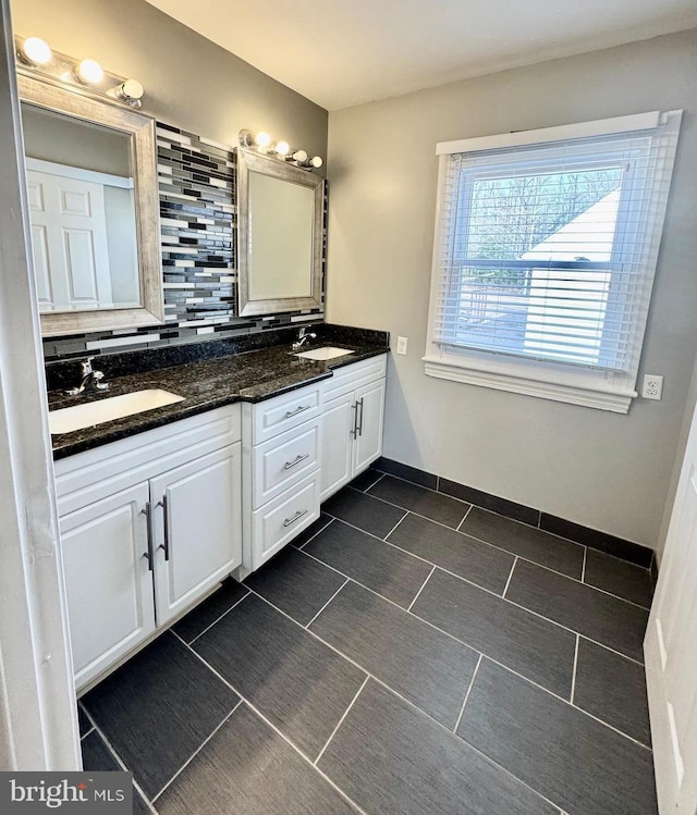 bathroom featuring double vanity, tasteful backsplash, and a sink