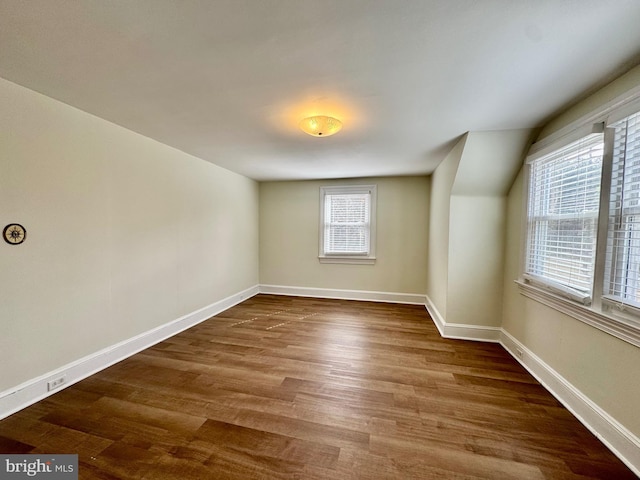 additional living space featuring baseboards and wood finished floors