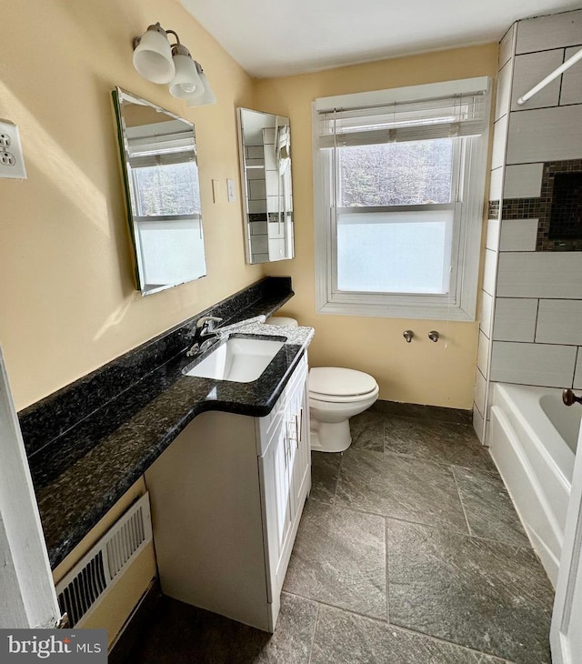 bathroom with vanity, toilet, and stone finish flooring