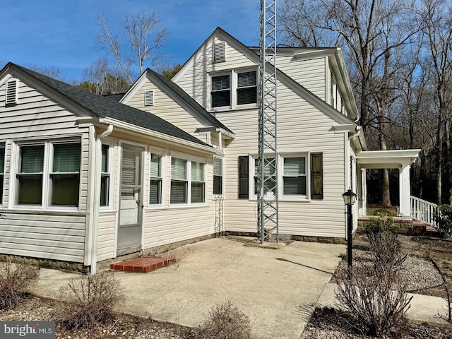 view of side of property with a shingled roof