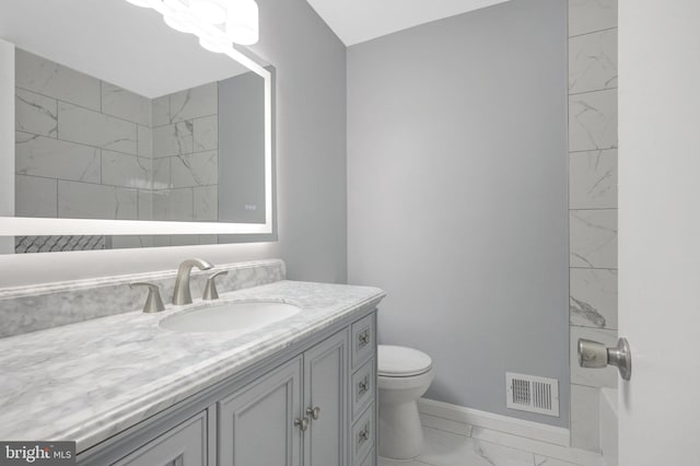 full bathroom featuring toilet, visible vents, vanity, baseboards, and marble finish floor