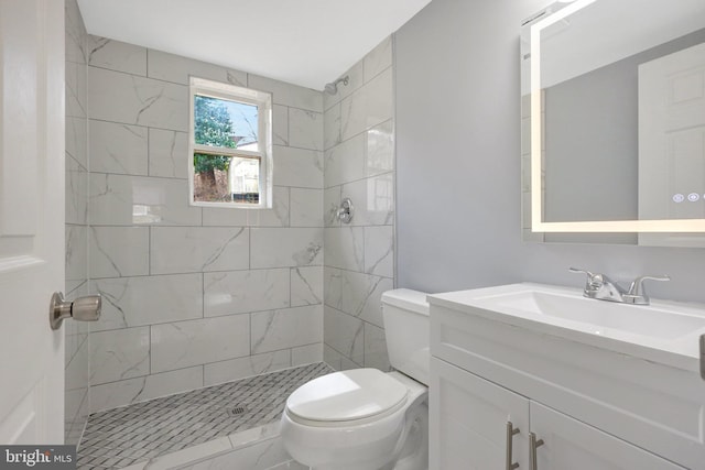 bathroom featuring toilet, a shower stall, and vanity