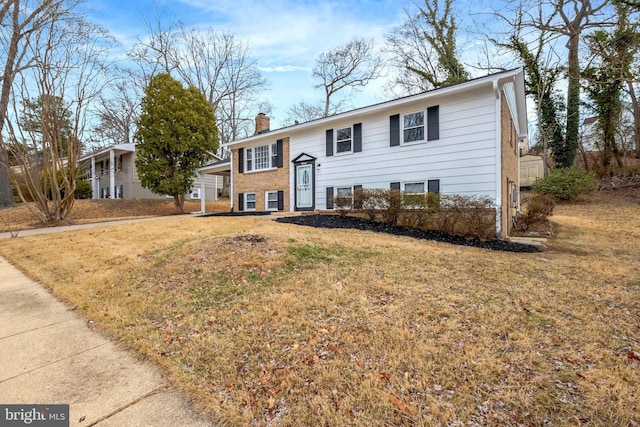 split foyer home with a chimney and a front yard