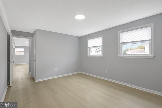 spare room with light wood-style floors and baseboards