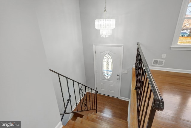 entrance foyer featuring visible vents, plenty of natural light, stairway, and wood finished floors