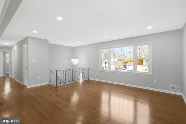 unfurnished room with baseboards, visible vents, wood finished floors, and recessed lighting