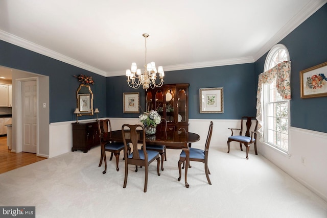 dining area with an inviting chandelier, crown molding, and light colored carpet