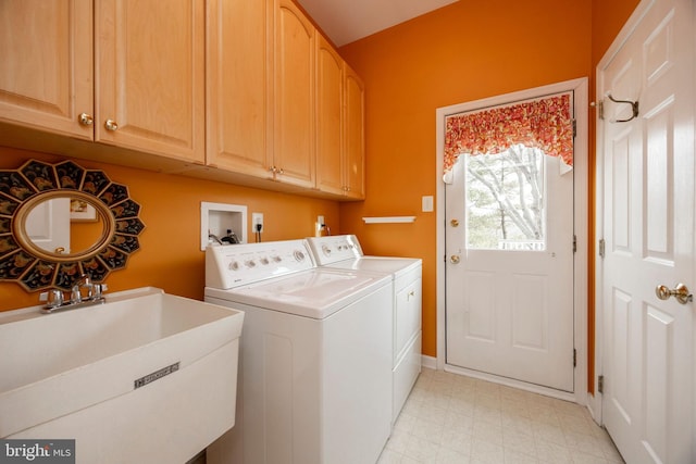 laundry area with cabinet space, a sink, washer and clothes dryer, and light floors