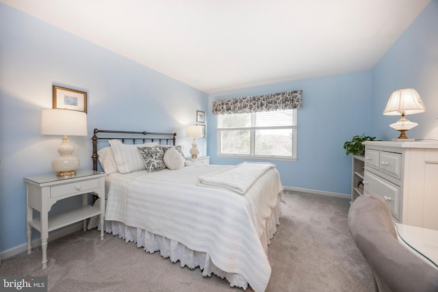 bedroom featuring baseboards and light colored carpet