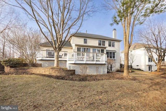 back of property with a lawn, a chimney, and a wooden deck