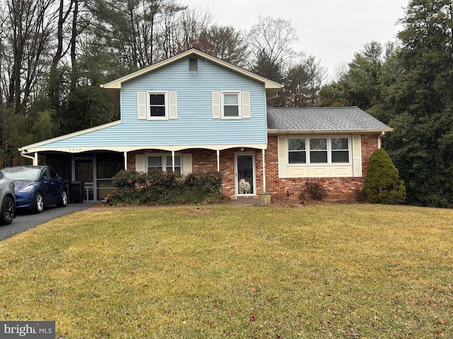 tri-level home featuring a front lawn and brick siding