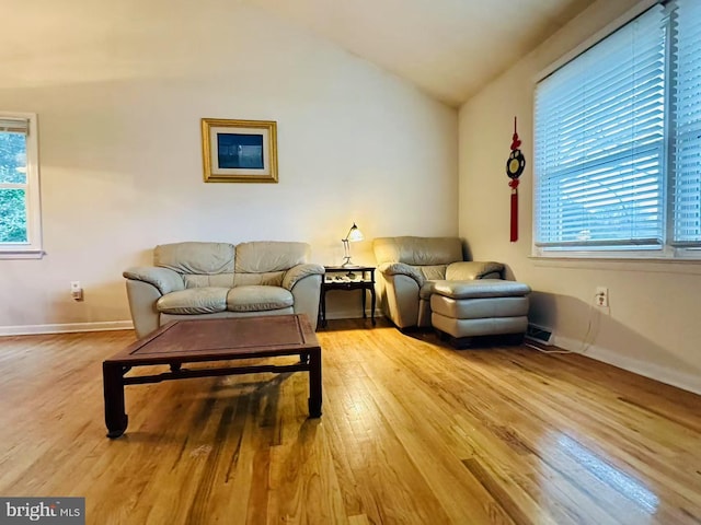 sitting room with baseboards, vaulted ceiling, and wood finished floors