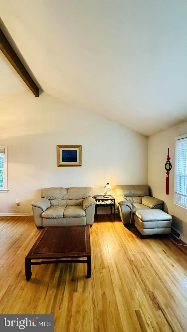 living room with lofted ceiling with beams, baseboards, and wood finished floors