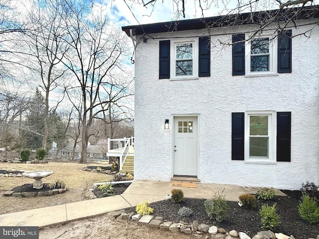 view of front of home featuring stairs and stucco siding