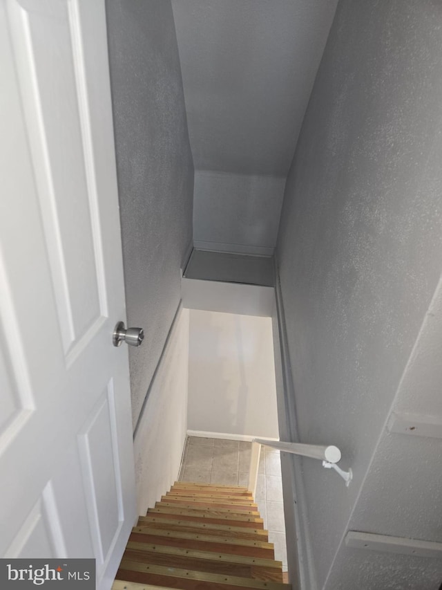 stairway with baseboards and wood finished floors