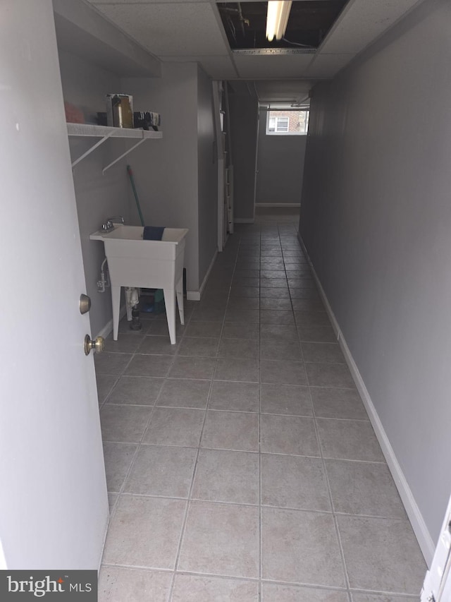 hallway featuring a sink and tile patterned flooring