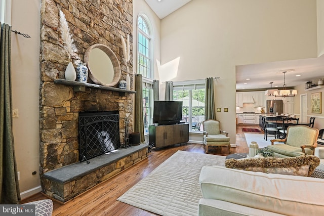 10310 Mystic Meadow Way, Oakton, VA 22124 - living room featuring a stone fireplace, a towering ceiling, wood finished floors, and a wealth of natural light