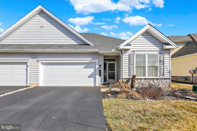 view of front of property featuring aphalt driveway, stone siding, a shingled roof, and a garage