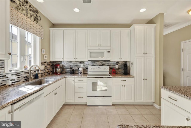 kitchen featuring white cabinetry, white appliances, light tile patterned flooring, and a sink