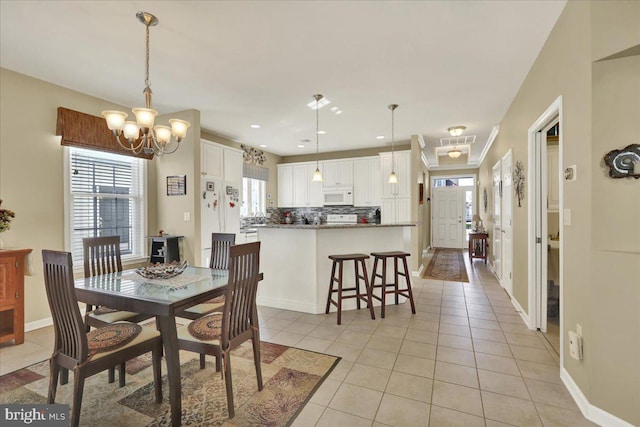 dining room featuring light tile patterned floors, a healthy amount of sunlight, and baseboards