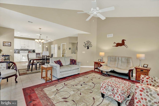 living room featuring ceiling fan with notable chandelier, light tile patterned floors, baseboards, and visible vents