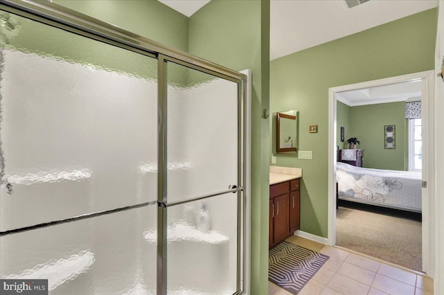 ensuite bathroom featuring a shower stall, baseboards, vanity, tile patterned floors, and ensuite bath