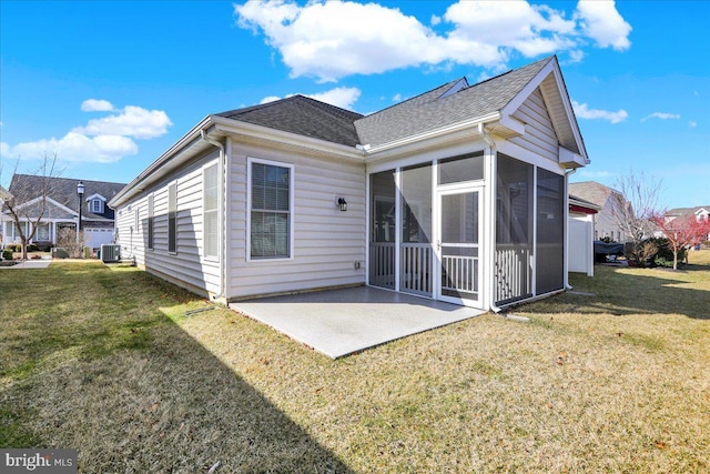 rear view of property with a yard, a patio, roof with shingles, and a sunroom