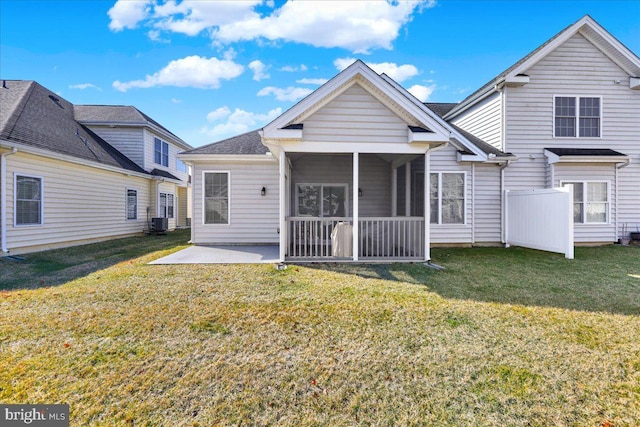 rear view of house with a patio, a lawn, central AC, and a sunroom