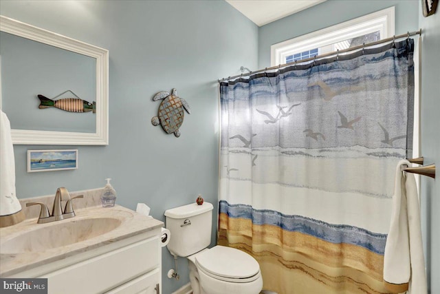 full bathroom featuring a shower with shower curtain, toilet, and vanity