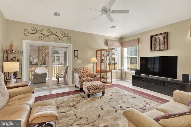 tiled living room featuring visible vents, baseboards, and a ceiling fan