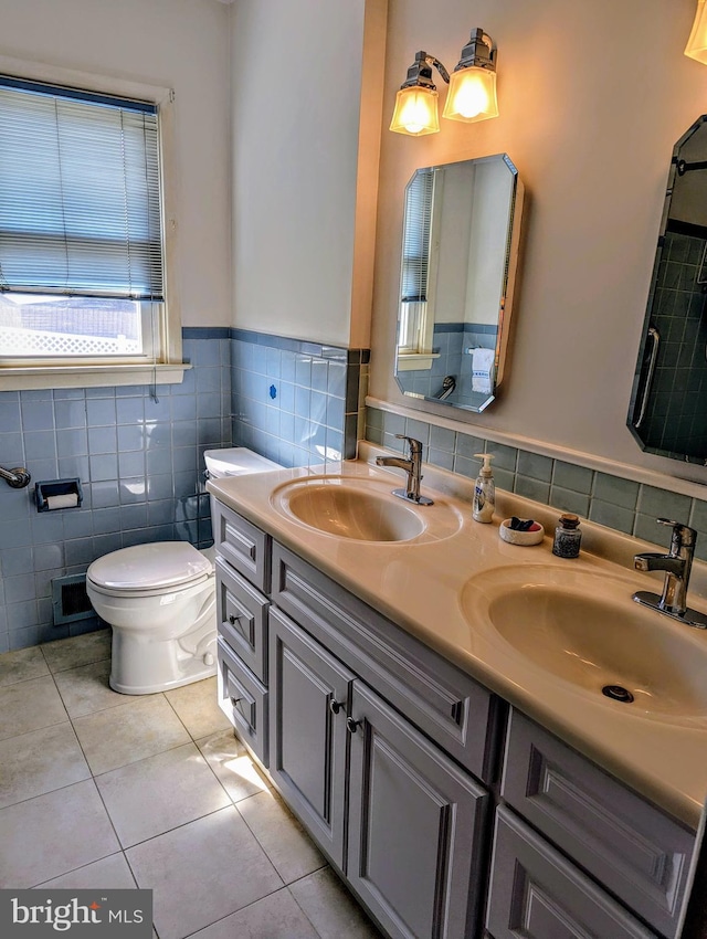 bathroom featuring a sink, toilet, double vanity, and tile patterned flooring