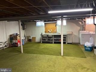 below grade area with golf simulator, plenty of natural light, and washing machine and clothes dryer