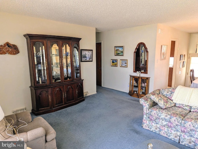 living room with carpet, visible vents, and a textured ceiling