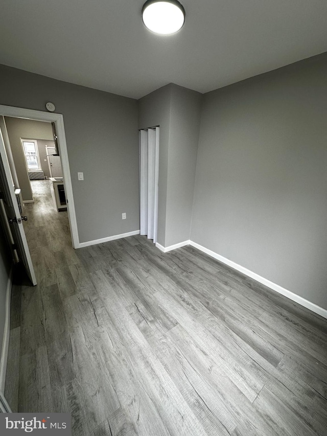 spare room featuring dark wood finished floors and baseboards