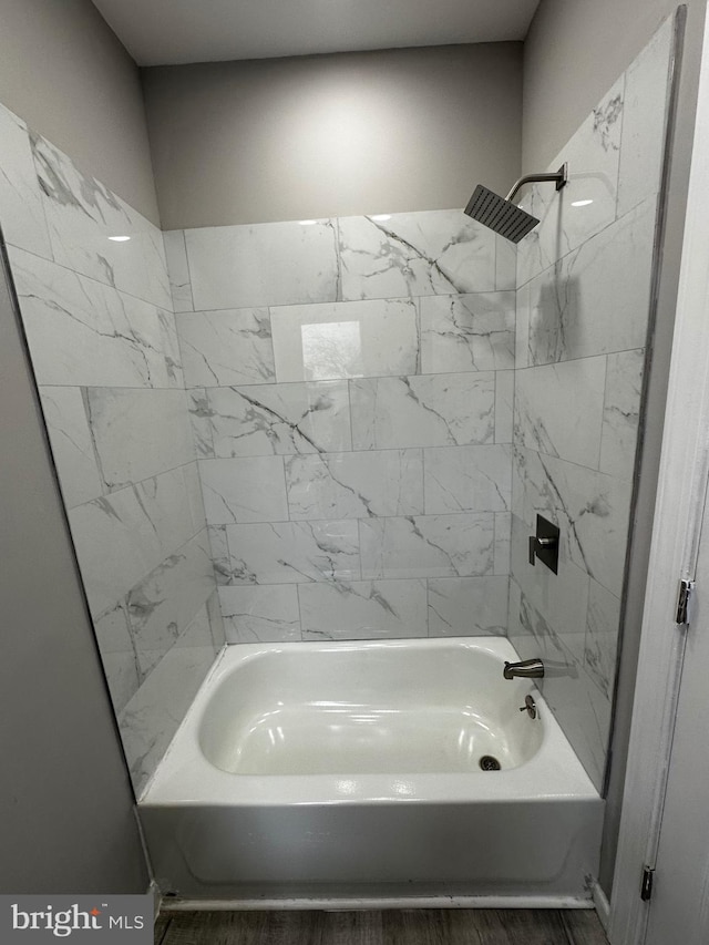 bathroom with shower / bathing tub combination and wood finished floors