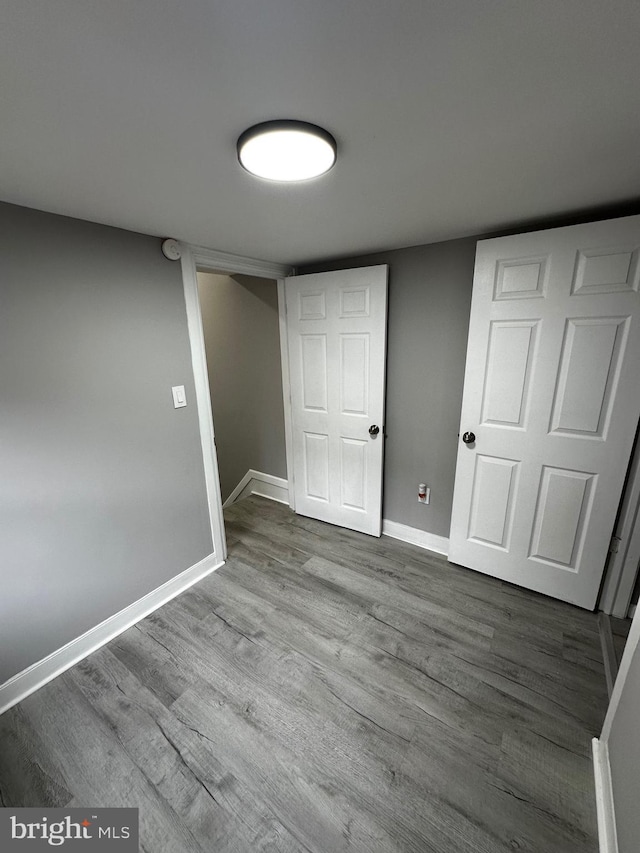 basement with baseboards and wood finished floors